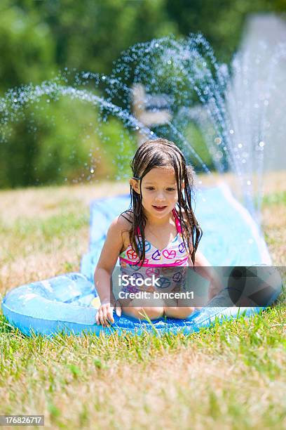 Estate Ragazza Slip Scorrere Verso Il Basso E Sprinkler In Tela Cerata - Fotografie stock e altre immagini di Tela cerata