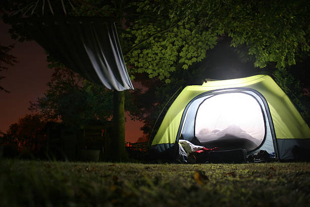 Illuminated tent and hamock at night stock photo