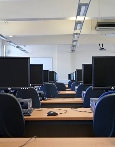 Interior view of a computer lab with rows of tables stock photo
