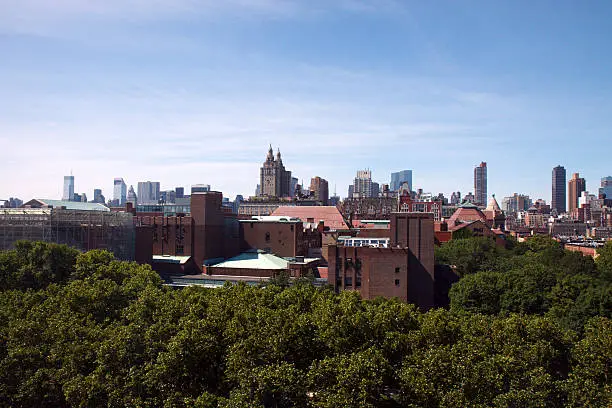 "Wide angle view of the Upper West Side of Manhattan, taken from a height of about 10 stories; green trees in the foreground and a blue sky backgroundMore NYC:"