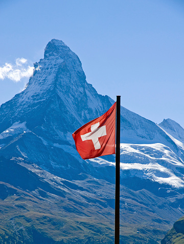 The swiss flag with the Matterhorn in the back