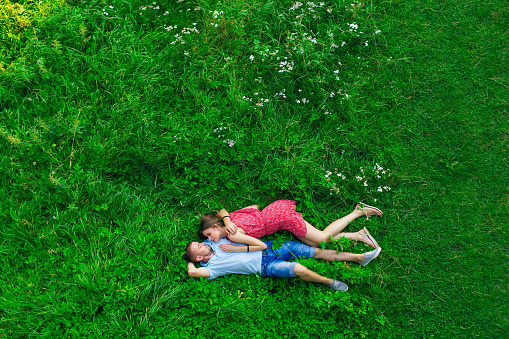 happy couple in love laying on the field on summer day. top view.
