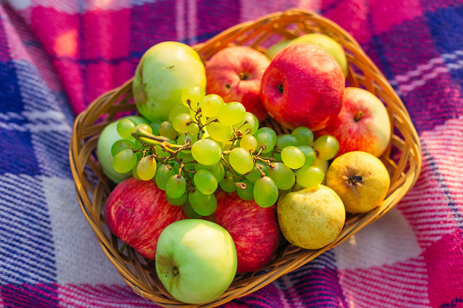 top view of fruit in basket. closeup of ripe fruits. apples, pears and grapes.