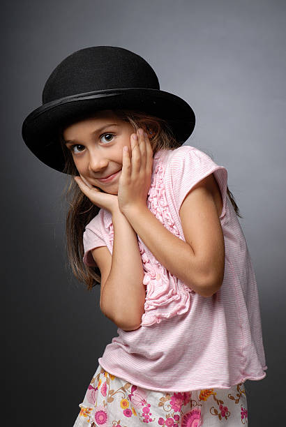 istock Girl wearing derby hat hands under her chin smiling 176828693
