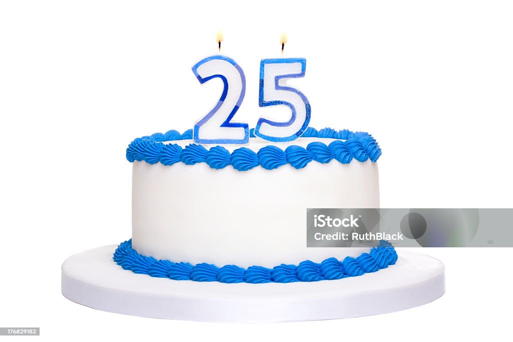 A white and blue iced 25th birthday cake with lit candles Birthday cake decorated with blue frosting and number twenty five candles Number 25 Stock Photo