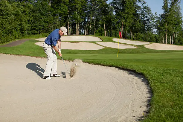 Golfer blasting out of bunker onto greenOther golf images: