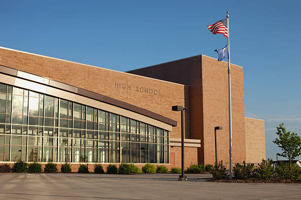 Modern high school with flagpole stock photo