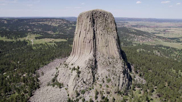 A drone shot of Devils Tower, a massive, monolithic, volcanic stout tower, or butte, located in the Black Hills region of Wyoming.