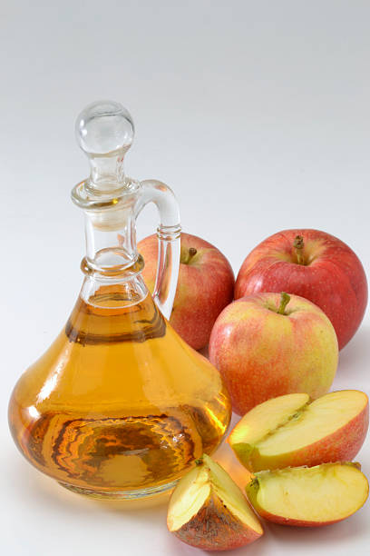 Apple cider vinegar with sliced and whole apples stock photo