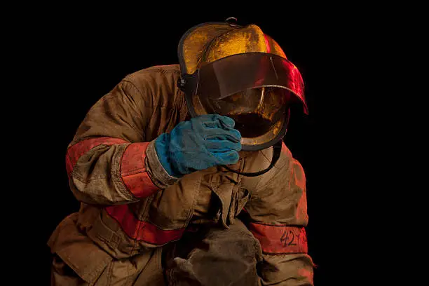 Photo of Fireman looking and reaching down.