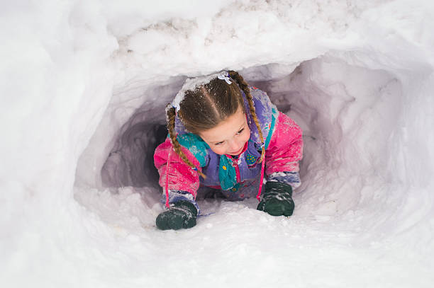 istock Young girl crawling through snow tunnel 176833070