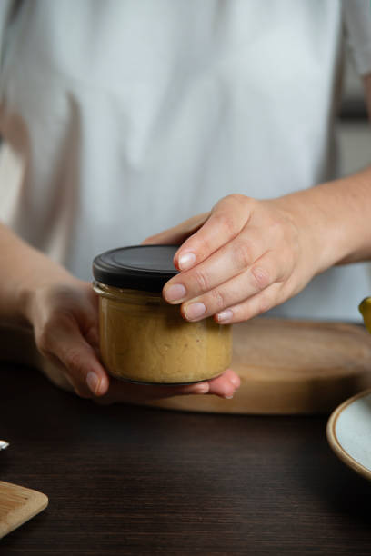 istock Peanut butter in woman hands in the kitchen. 1768336243