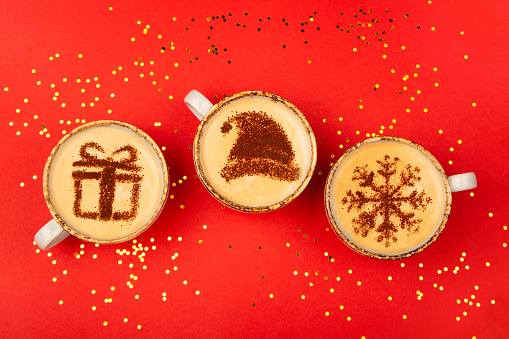 Christmas concept design on coffee cups on red background.