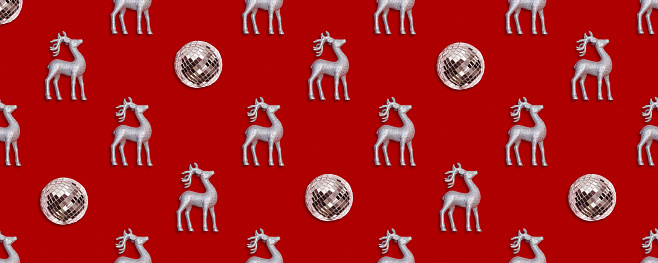 Seamless New Year and Christmas pattern with mirrored disco balls and silver deers on a red background. High quality photo