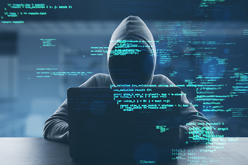 Hacker at desk using laptop with creative coding html language on blurry office interior background. Web developer, hacking, malware and programming concept. Double exposure