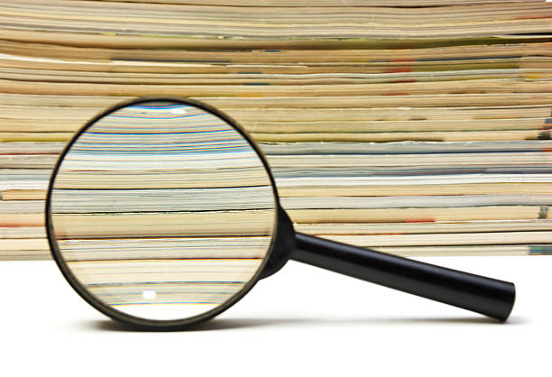 istock magnifying glass and stack of magazines 176835439