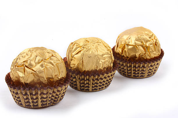 istock Three sweet chocolate bonbons in golden foil 176835590
