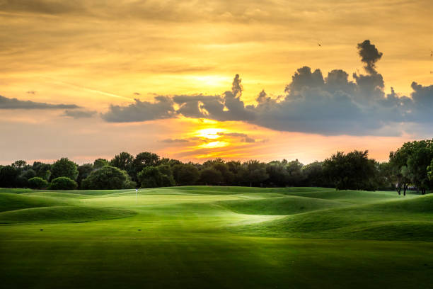 pôr do sol sobre um campo de golfe texano - golf golf flag sunset flag - fotografias e filmes do acervo