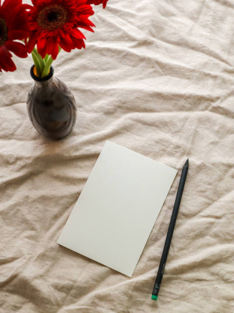 istock White Paper and A Brown Vase with Gerbera Flowers on Beige Fabric. 1768367343
