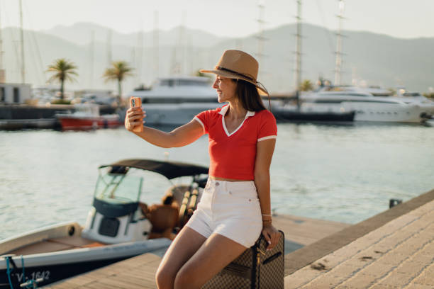 istock Woman with a suitcase taking a selfie during a vacation at the seaside 1768369569