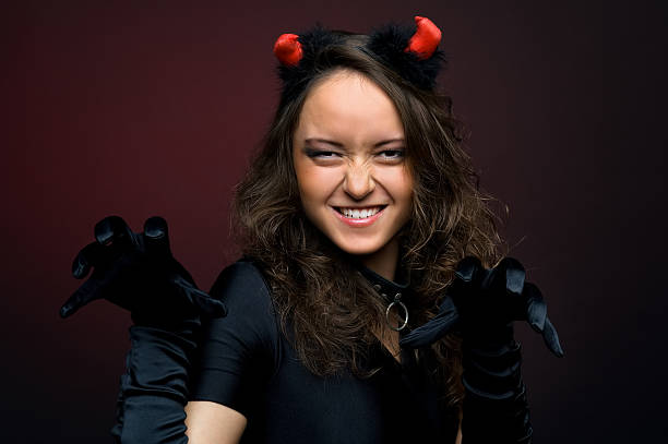 istock beautiful young woman in devil costume 176837057