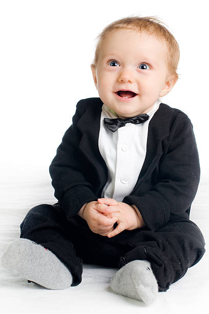 sweet laughing baby in tailcoat sitting on white ground