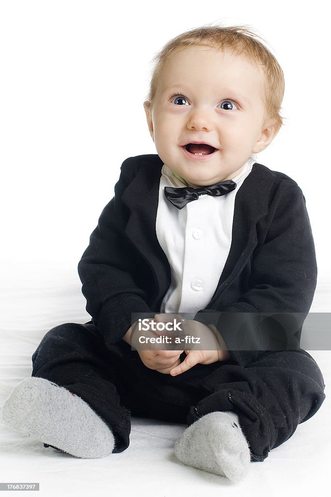 sweet baby in tailcoat sweet laughing baby in tailcoat sitting on white ground Attitude Stock Photo