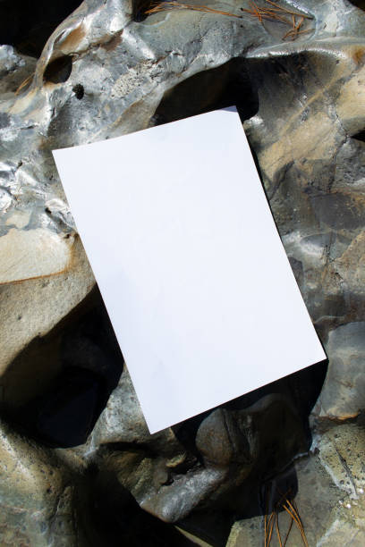 istock Mockup sheet on large mountain stones in diffused sunlight. Layout of poster on stone 1768385127