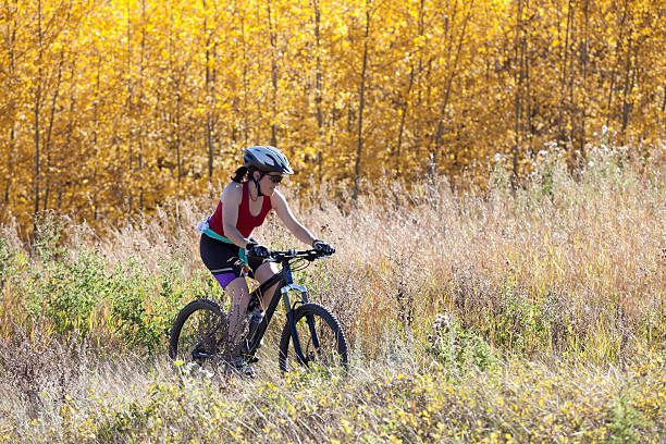 Woman mountain biking on autumn day stock photo
