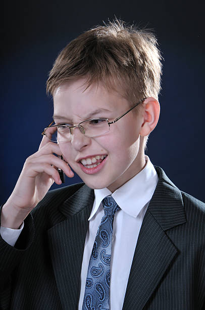 Boy in Suit on Cellphone stock photo