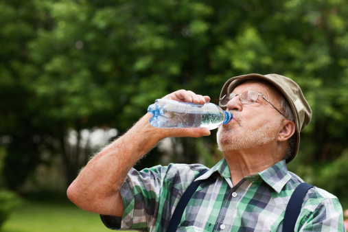 Senior man drinking bottled water