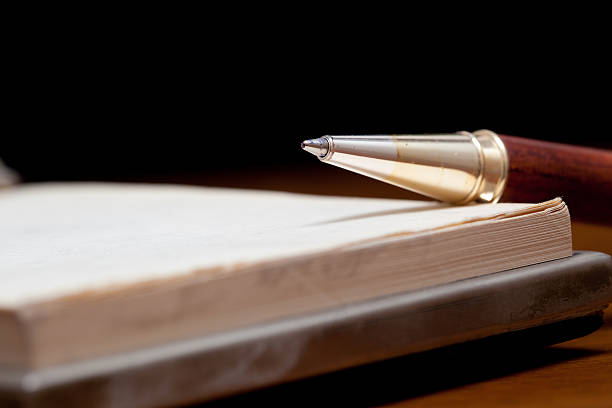 istock Elegant pen lying on a notebook with dark background 176840305