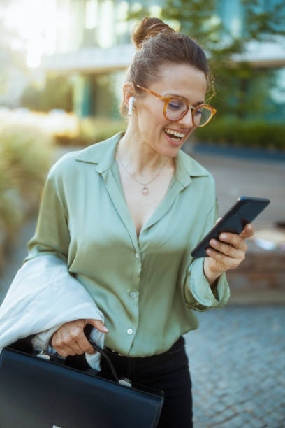istock happy modern female worker in green blouse and eyeglasses 1768405672