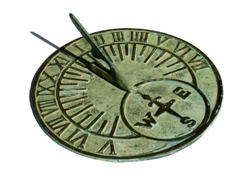 Horizontal close up of part of antique table clock in bronze metal with intricate detailed design sitting in rural country hallway Australia