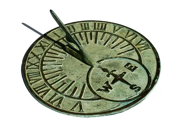 "An old brass sundial, with a delicate green patina, showing mid-day. Isolated on white with a clipping path."