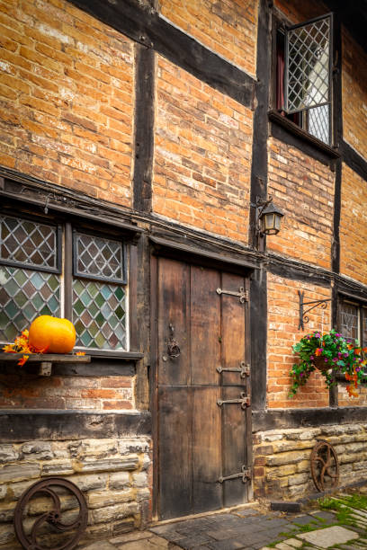 Stratford-Upon-Avon, UK. Sunday 29 October 2023. A pumpkin outside an old house with a wooden door on a street in Stratford-Upon-Avon.