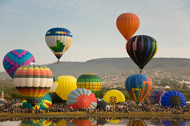 multiple hot air balloons lifting off Multiple hot air balloons lifting off during Festival internacional del globo in Leon Mexico ballooning festival stock pictures, royalty-free photos & images