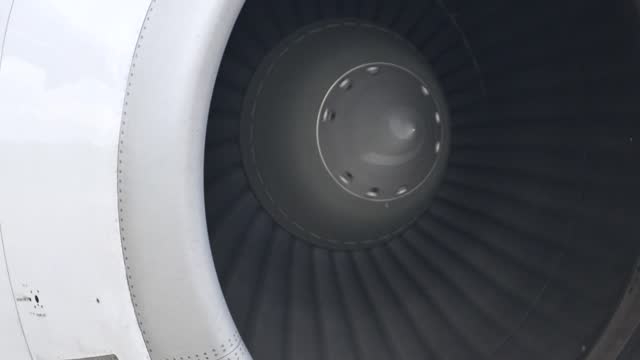 Huge airplane jet engine close up view moving forward heat haze distant airplane lining up behind. 4k super slow motion raw video 120 fps