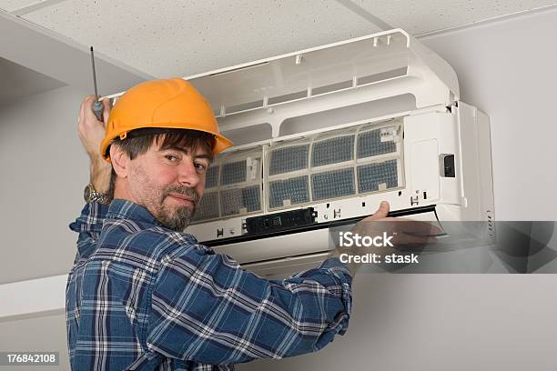 Technician Fixing Air Conditioner Stock Photo - Download Image Now - Air Conditioner, Building Contractor, Heat - Temperature