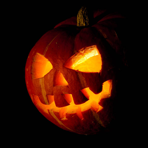halloween, old jack-o-lantern on black Scary old jack-o-lantern on black background. halloween pumpkin human face candlelight stock pictures, royalty-free photos & images