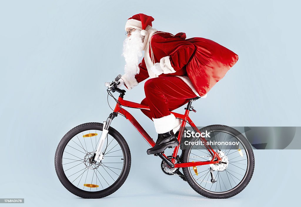 Santa en bicicleta regalos en rojo bolsa de transporte - Foto de stock de Andar en bicicleta libre de derechos