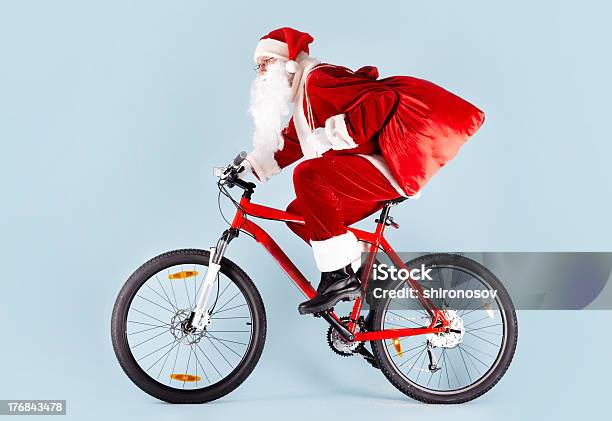 Santa En Bicicleta Regalos En Rojo Bolsa De Transporte Foto de stock y más banco de imágenes de Andar en bicicleta