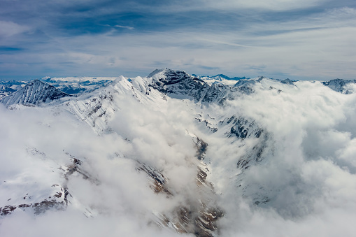 Aerial view of snow mountain range landscape with clouds. Alps mountains, Austria