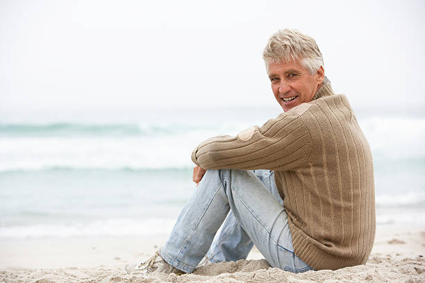 istock Senior Man On Holiday Sitting At Winter Beach 176843617