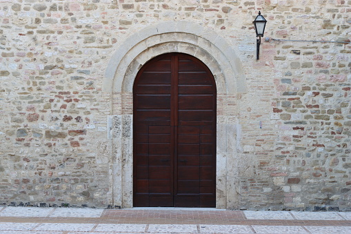 Wooden door with a stone archway, set in a stone wall
