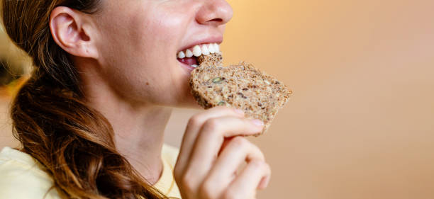 istock Young woman eating healthy multigrain bread close up. 1768441476