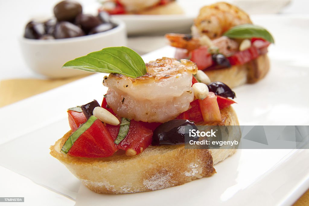 Shrimp Bruschetta Plate of delicious Olive - Tomato Bruschetta with garlic shrimp and pine nuts. Antipasto Stock Photo