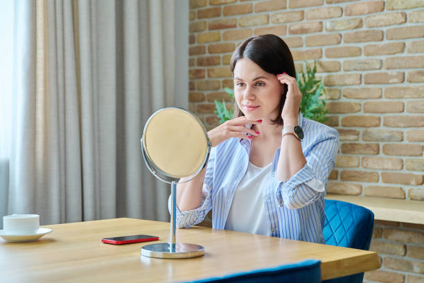 istock Young happy brunette looking at her face in mirror 1768460179