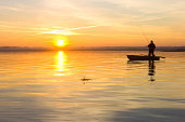 Fisherman on a boat at sunset
