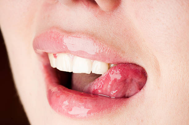 istock young female licking her pink lips 176846722